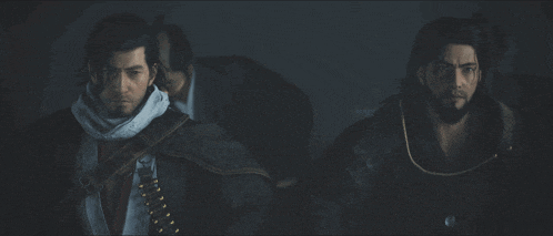 two men standing next to each other in the dark