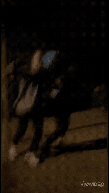 a man is standing in front of a car at night while another man stands behind him