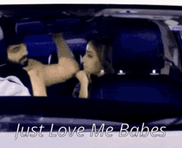 a man and a woman are sitting in a car with the words just love me babes below them