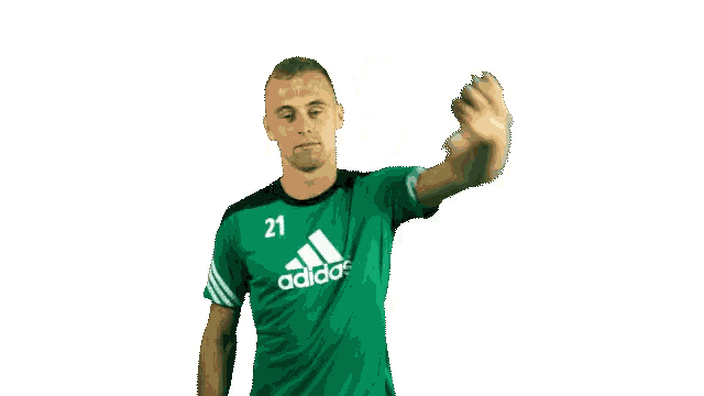 a man wearing a green adidas shirt is waving