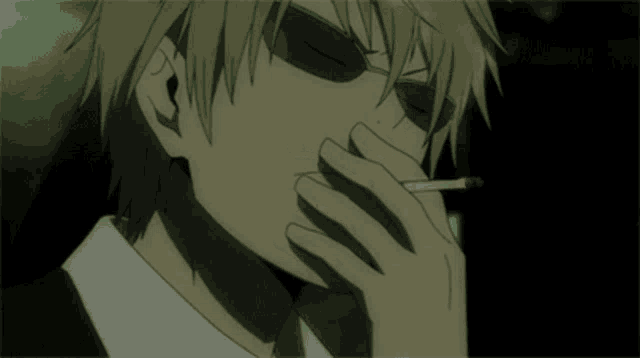 a man in sunglasses is smoking a cigarette in the dark