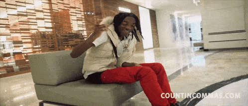 a man is sitting on a couch with the website countincommas.com visible in the corner