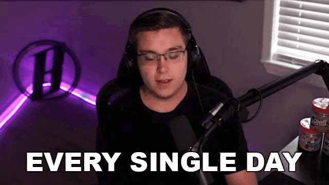 a man wearing headphones and glasses is sitting in front of a microphone with the words every single day below him .