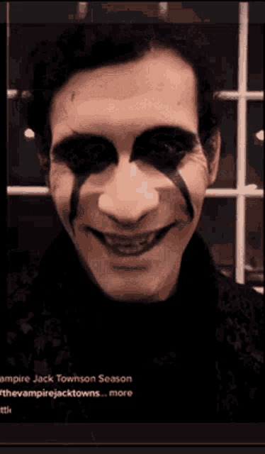 a close up of a man 's face with black paint on it