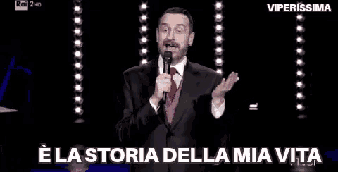 a man in a suit and tie is holding a microphone .