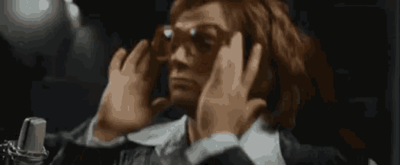 a man with red hair is wearing sunglasses and a suit .