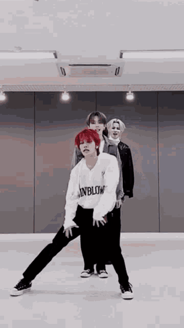 a group of young men are standing in a room dancing .