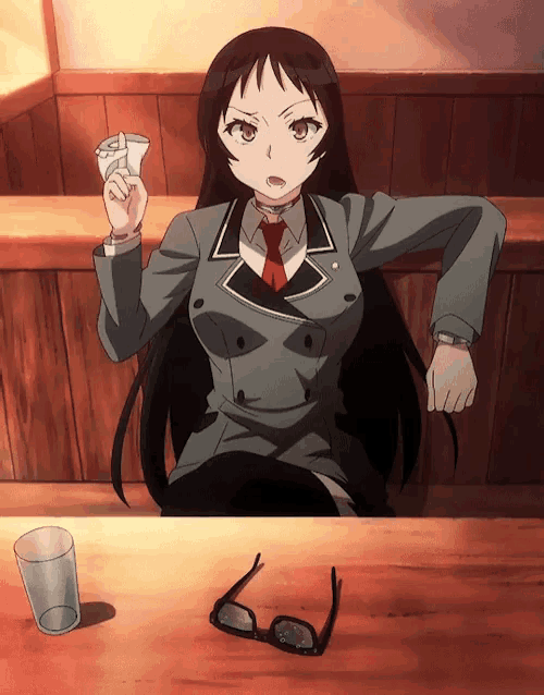 a girl is sitting at a table with glasses and a glass of water