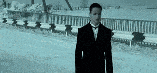 a man in a suit is walking down a snowy street