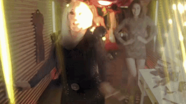 a woman in a black dress is standing in a room