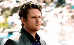 a man wearing a suit and a blue shirt is making a funny face .