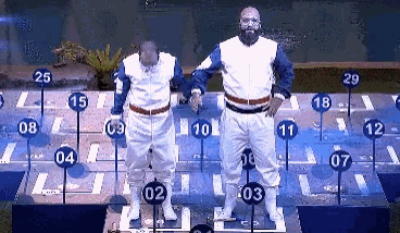 two men are standing in front of a grid of numbers including the number 29