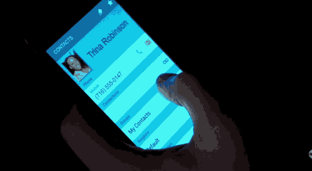 a person is holding a cell phone with the name trina robinson on it