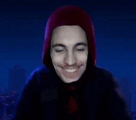 a man wearing a red hoodie and a red tie is smiling with his eyes closed