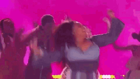 a woman is dancing on a stage in front of a crowd of people .