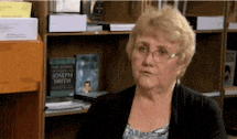 a woman is sitting in front of a bookshelf with a book titled joseph smith on it