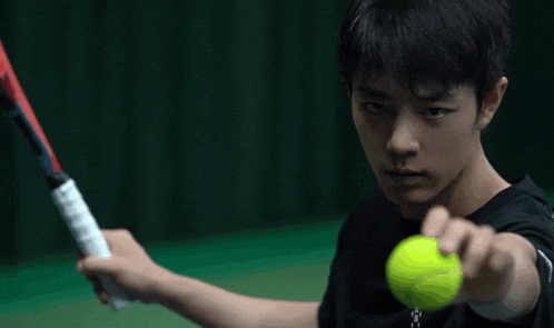 a man in a black shirt is holding a red tennis racket
