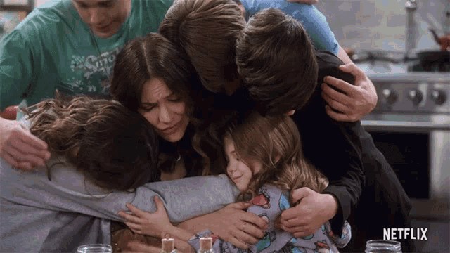 a group of people hugging with a netflix logo in the background