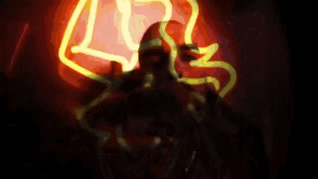 a man is singing into a microphone in front of a neon sign that says ' ls ' on it .