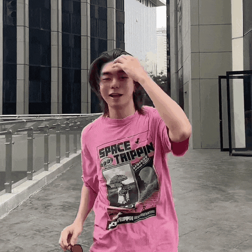 a man wearing a pink shirt that says space trippin on it