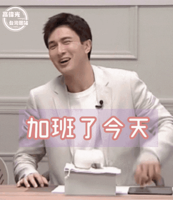 a man sitting at a table with chinese writing on the bottom