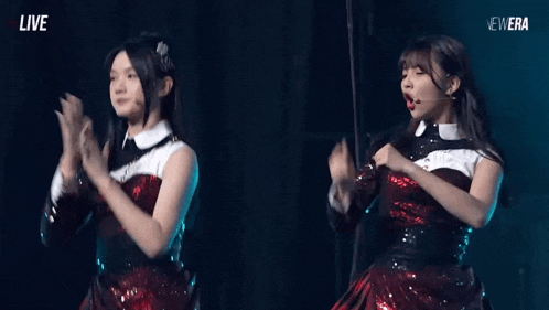 two girls are dancing on a stage with the words live on the bottom