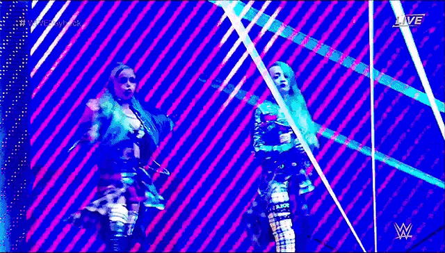 two women are dancing in front of a striped background and the words live are on the bottom right