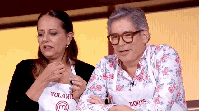 a man and a woman wearing aprons that say yoland