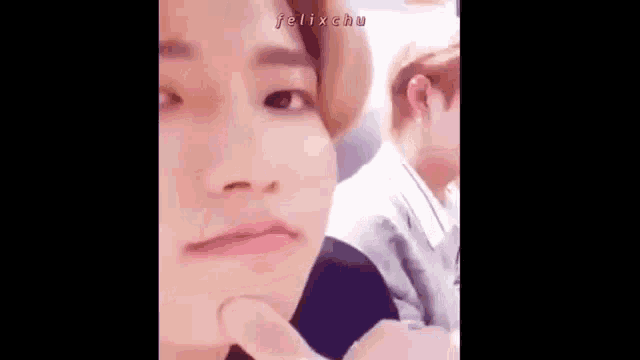 a close up of a person making a funny face with their hand on their chin .