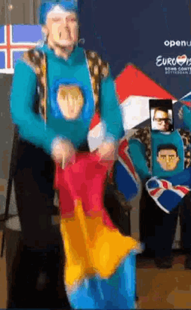a man in a superhero costume is holding a red and yellow item in his hands .