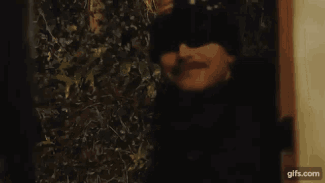 a man in a mask is standing in front of a door .
