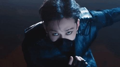 a close up of a man wearing a mask and a black jacket .