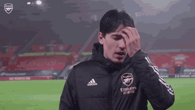a man wearing a jacket with emirates fly better on it