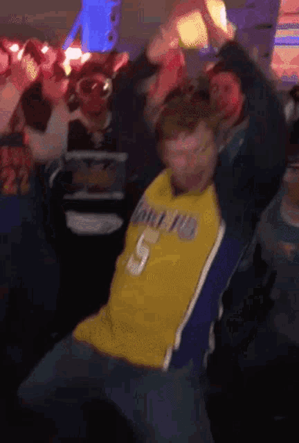 a man in a lakers jersey is dancing