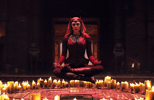 a woman sits in a lotus position in front of candles