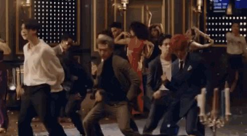 a group of people are dancing together on a dance floor in a room .