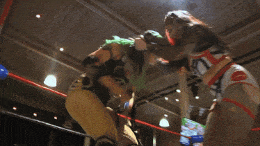 a wrestler with green hair is jumping in the air