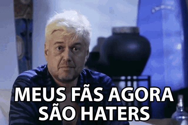 a man with white hair and a beard has the words meus fas agora sao haters written below him