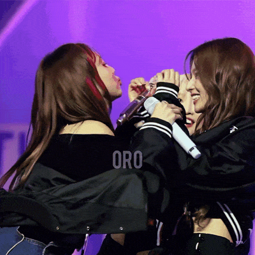 three women are hugging each other and the word oro is on the purple background