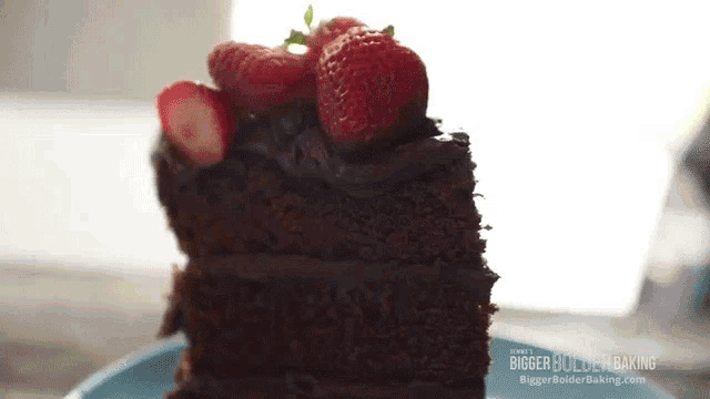 a slice of chocolate cake with strawberries on top is on a blue plate ..