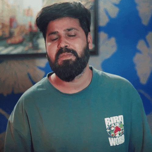 a man with a beard wears a green shirt that says bird on the word