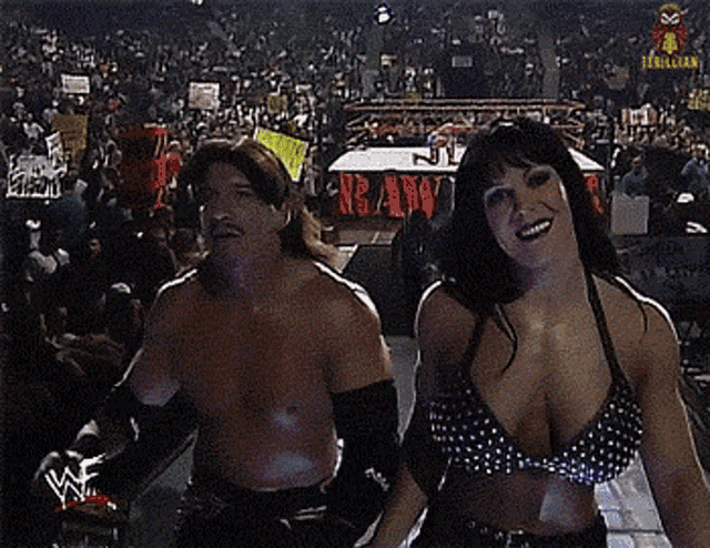 a man and a woman are standing in front of a crowd with a sign that says r.b.a.d.w.