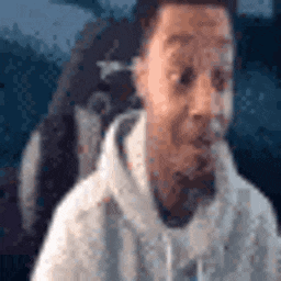 a man in a white hoodie is sitting in a chair with his mouth open .