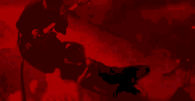a person is laying on a bed in a dark room in a red light .