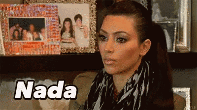 a woman in a ponytail is sitting on a couch in front of a shelf with pictures and the word nada .