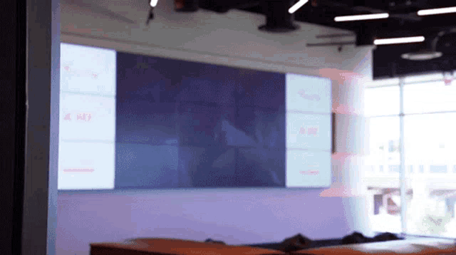 a room with a purple wall and a large screen that says a on it