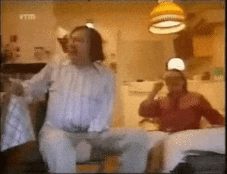 a man and a woman are sitting on a couch in a room .