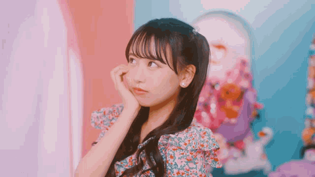 a girl in a floral dress is looking at something