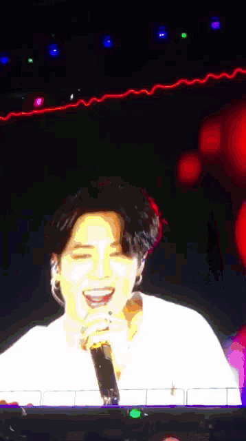 a blurry picture of a man holding a microphone