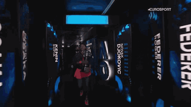 a man holding a trophy in a tunnel that says eurosport on it